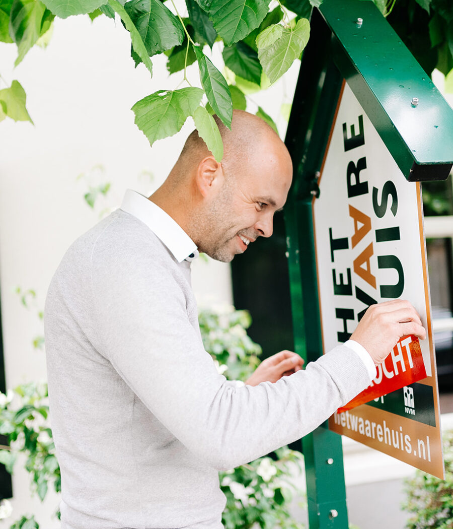 Makelaar Jasper van den Broek plakt verkocht sticker