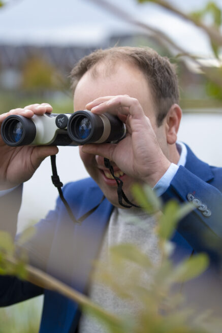 Makelaar van Het Waare Huis met verrekijker